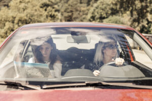 Woman driving with her female friend looking at a map